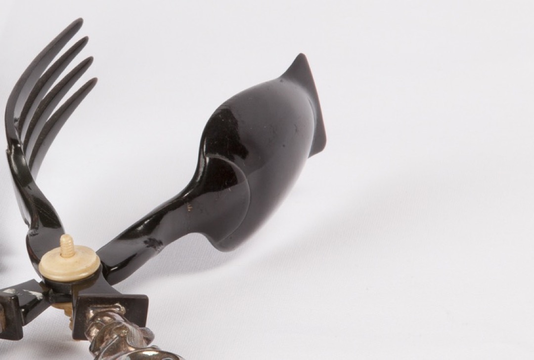 Antique French scissor-action salad tongs with fork and spoon heads, a visible pivot screw and looped silver handles